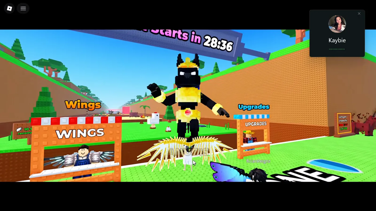 Wings stand at spawn in +1 Wings For Eggs with a countdown board overhead while a player wearing Anubis Wings stands beside the WINGS and UPGRADES stalls